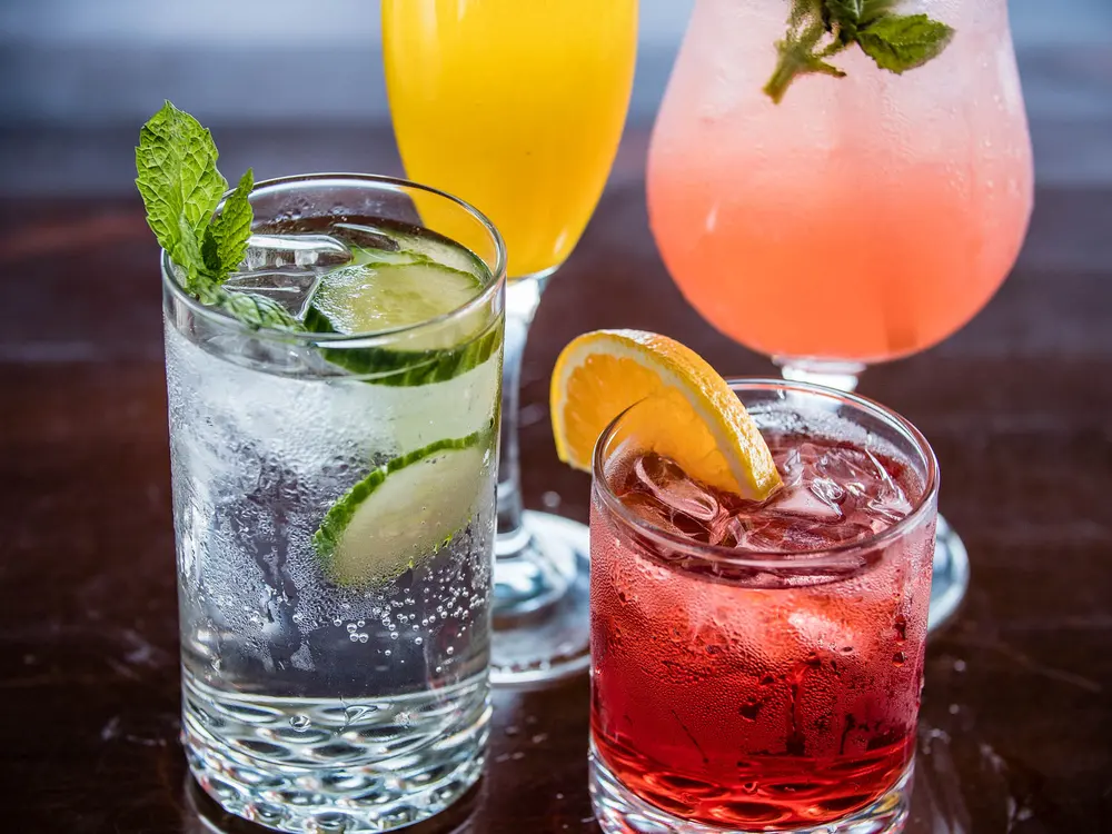 Cocktails with lime and cherry in tall glasses