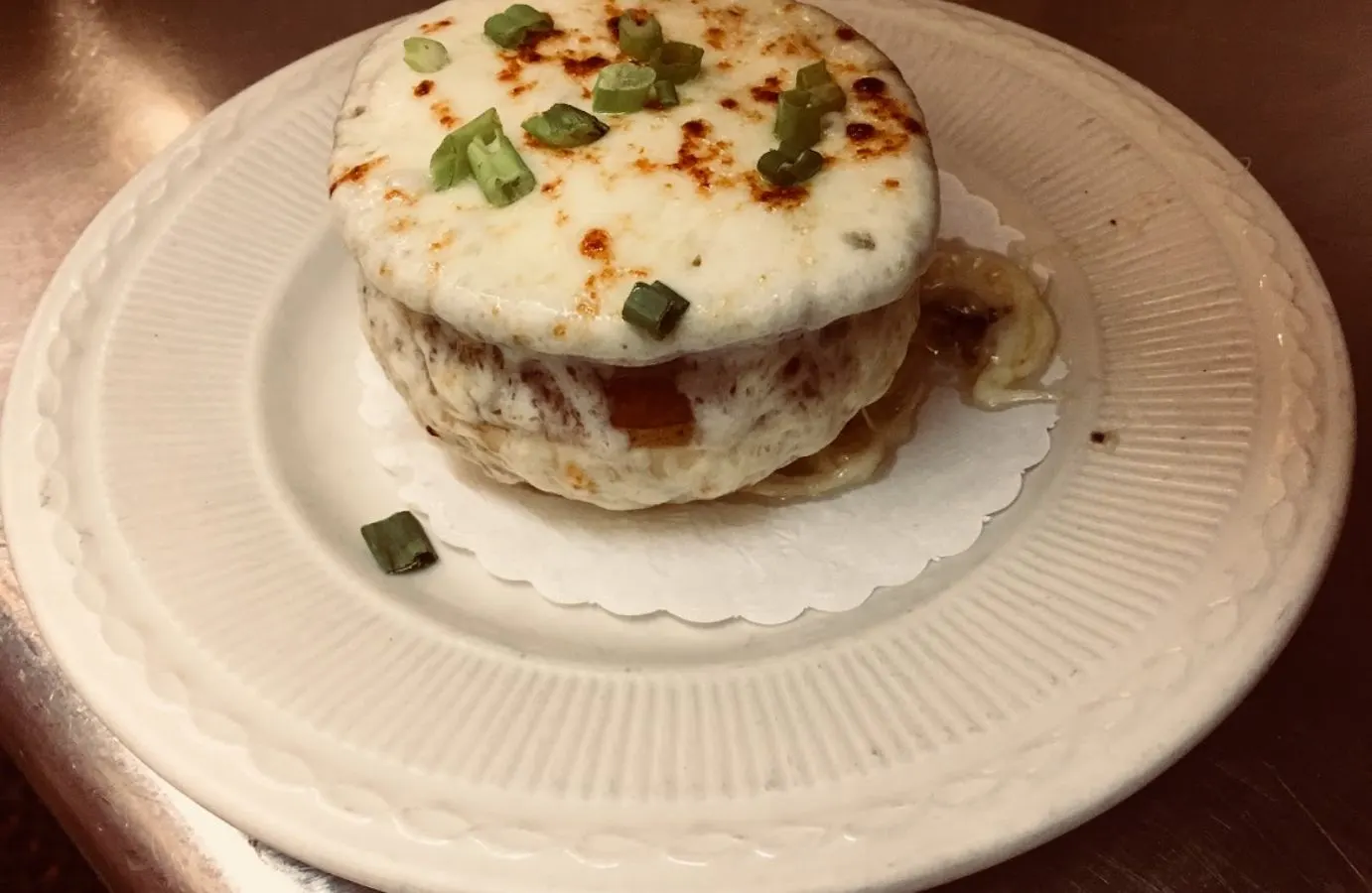 A crab cake topped with melted cheese